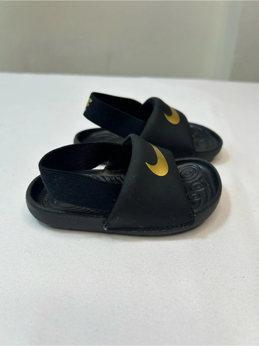 Nike Kids Black Slides with Gold Swoosh and Elastic Heel